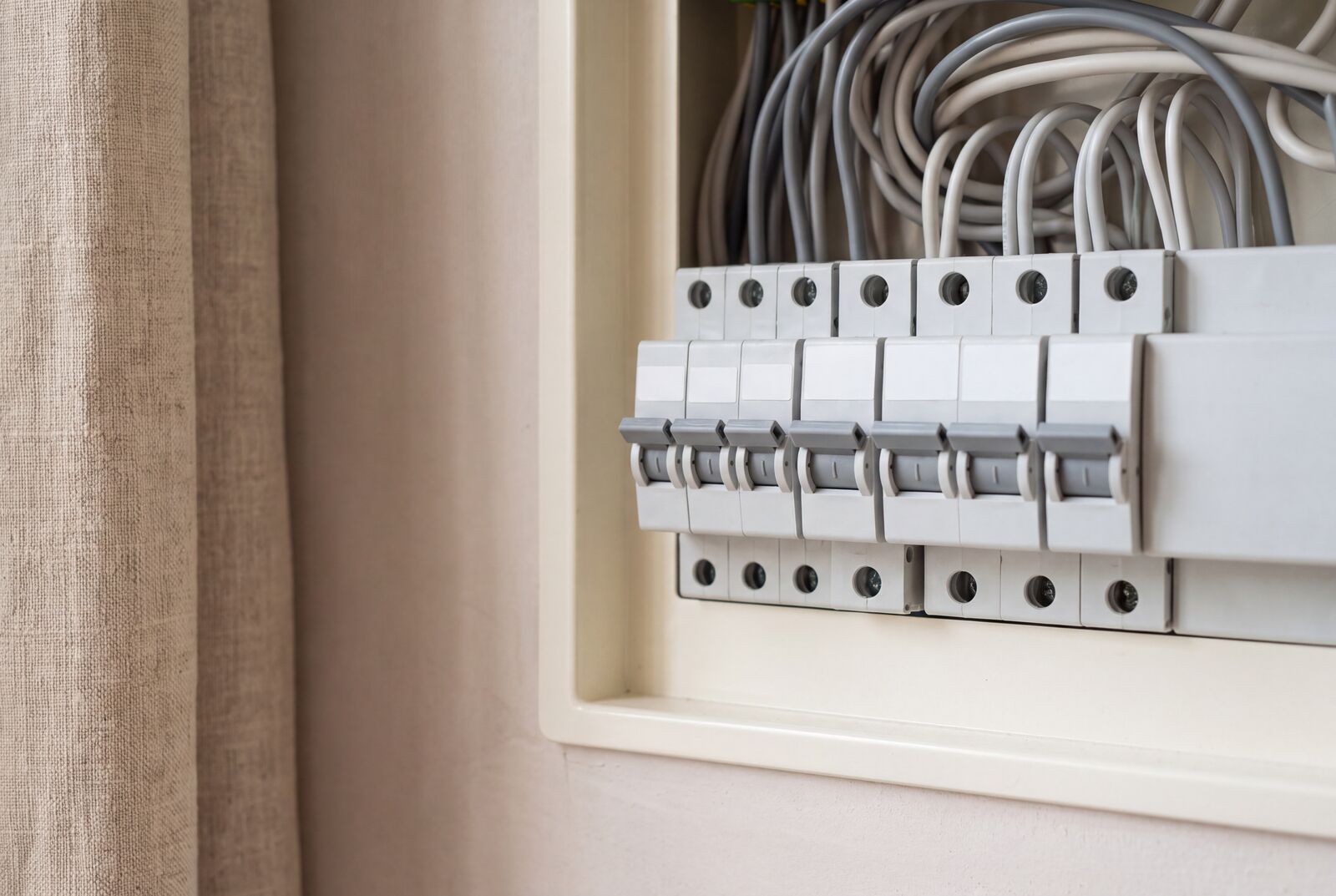 Product still: circuit breakers clipped to a DIN rail on linen